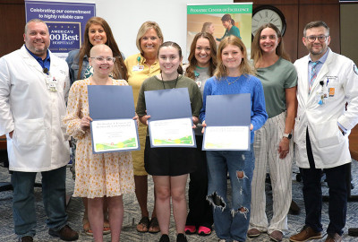 (L-R) Front row: Scholarship winners Jadyn Byron, Laykin Hayes, Bella Masters; Back row: Dr. Josh Hess, pediatric hematologist and oncologist, Edwards Comprehensive Cancer Center (ECCC); Monica Littlejohn, pediatric oncology nurse, ECCC; Kristi Arrowood, executive director, MHN Foundations; Jodi Smith, pediatric oncology nurse, ECCC; Courtny Lewis, pediatric oncology nurse, ECCC; Dr. Paul Finch, pediatric hematologist and oncologist, ECCC